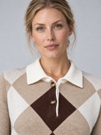 Close-up of beige argyle knit sweater showing white pointed collar, two brown buttons and knitted diamond pattern