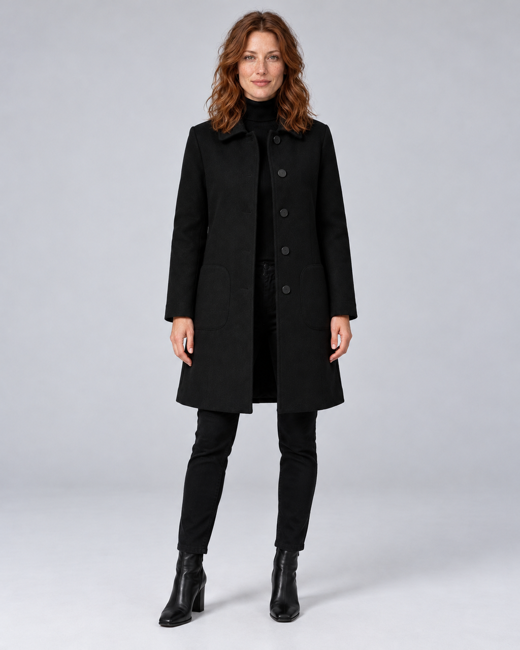 Woman wearing black tailored longline wool-blend coat with button front and side pockets, front view