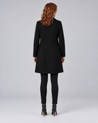 Woman wearing black tailored longline wool-blend coat with button front and side pockets, rear view