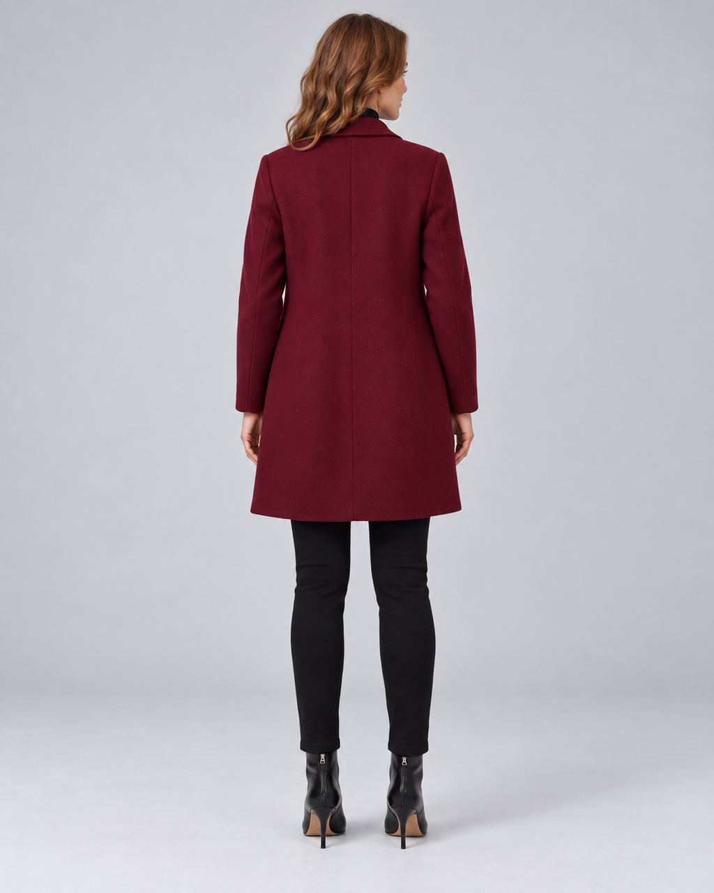 Woman wearing wine tailored longline wool-blend coat with button front and side pockets, rear view