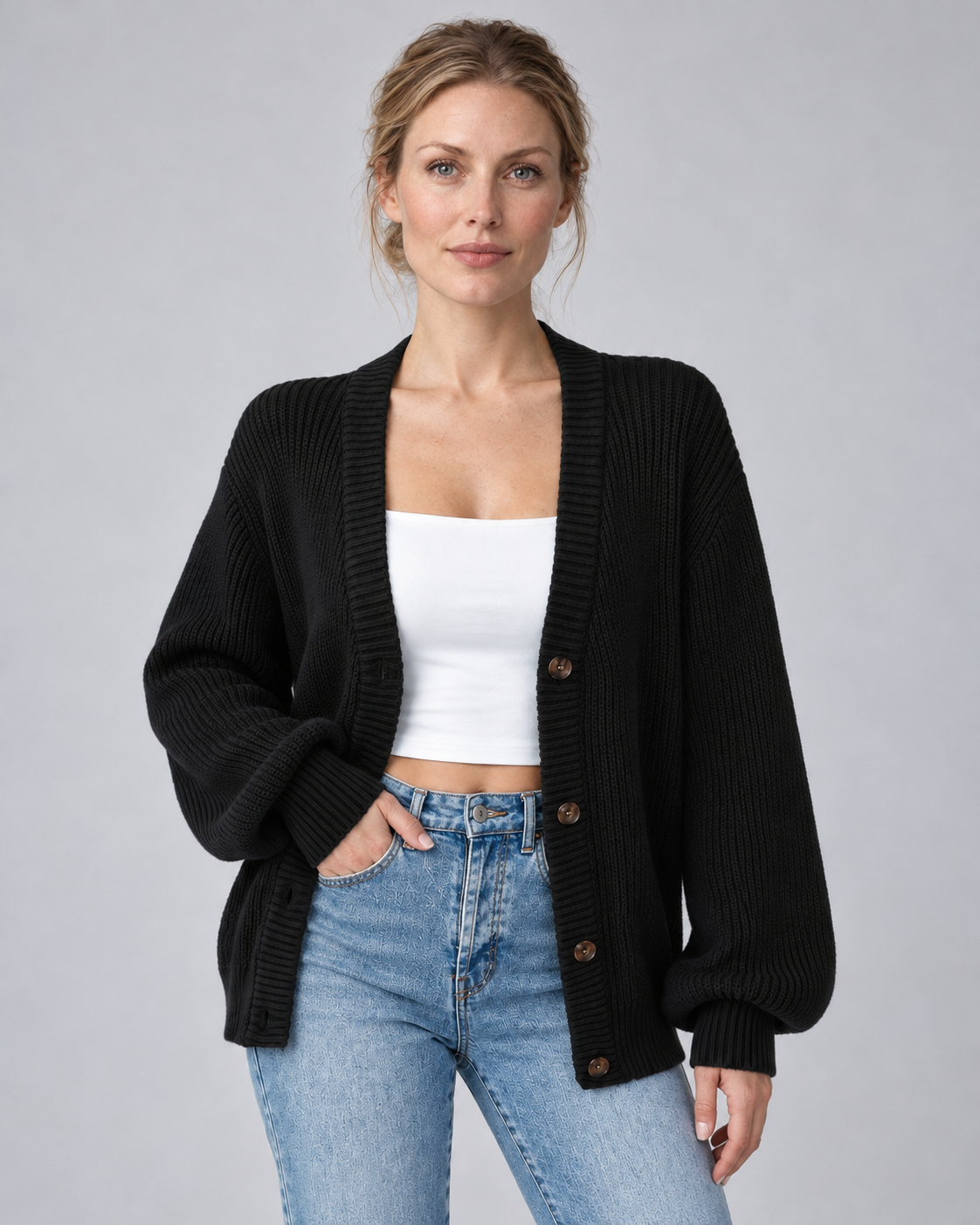 Woman wearing black V-neck ribbed button-front cardigan with long sleeves, front view