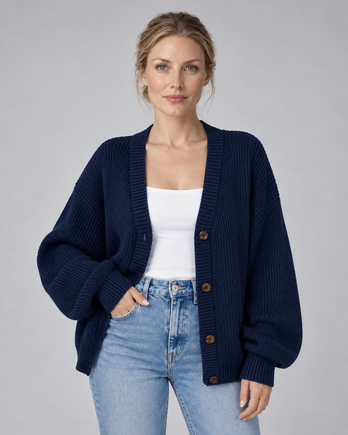 Woman wearing navy V-neck ribbed button-front cardigan with long sleeves, front view