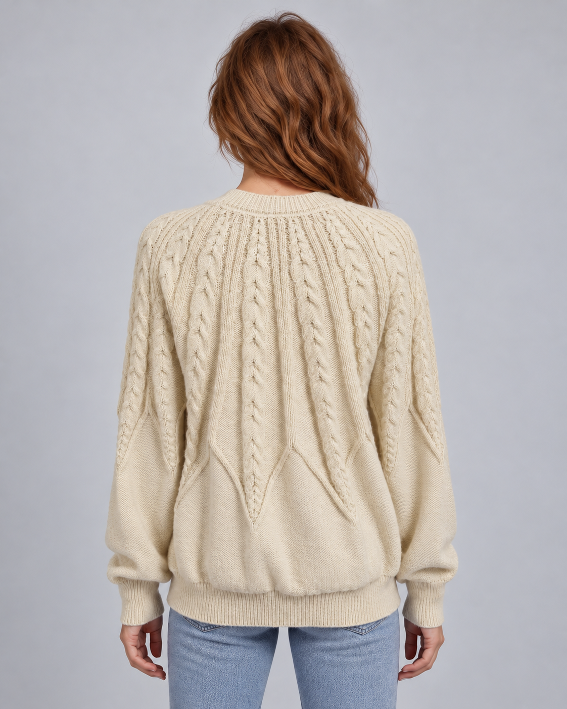 Cream cable-knit jumper rear view showing elongated cable yoke and ribbed hem